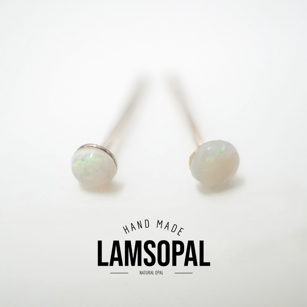 A pair of handmade stud earrings with round white natural opal cabochons on silver-toned posts, displayed on a clean white background with a 'LAMSOPAL' brand logo overlay.
