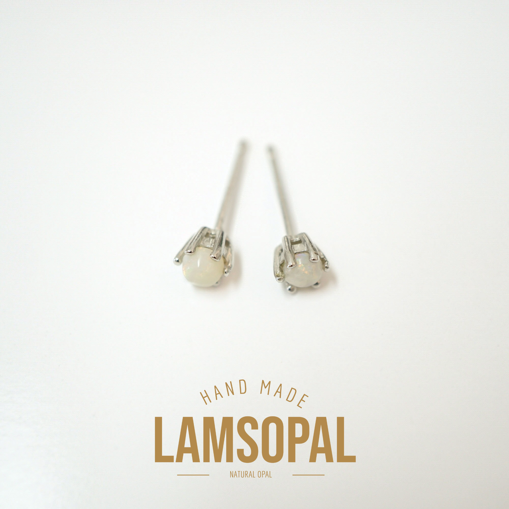 A pair of Lamsopal natural opal stud earrings with silver-toned settings, displayed on a clean white background with a gold-colored 'HAND MADE LAMSOPAL NATURAL OPAL' text overlay at the bottom.