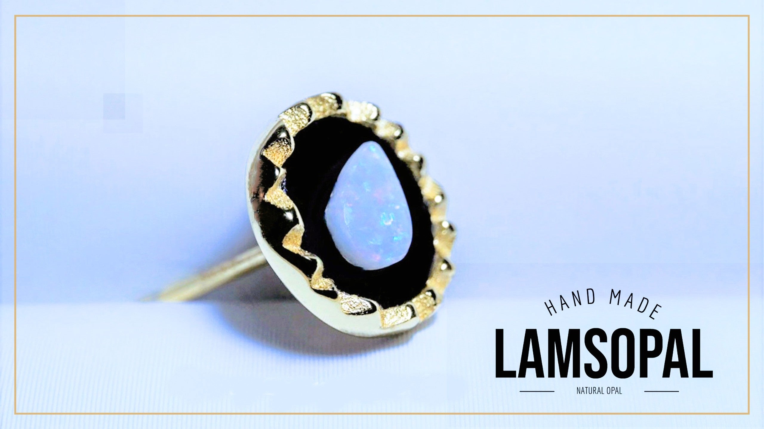 A handmade Lamsopal natural opal ring with a gold bezel and black resin setting, shown on a light blue background with a gold border and text overlay.