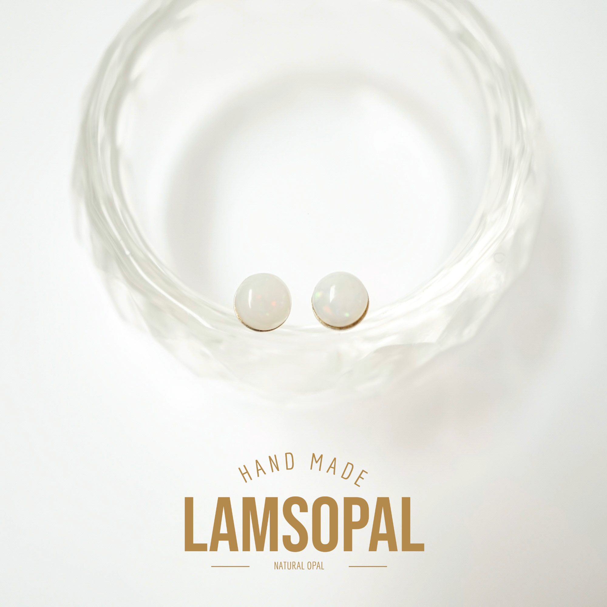 Two round natural opal stud earrings displayed inside a clear textured glass bowl, with the text 'HAND MADE LAMSOPAL NATURAL OPAL' below on a white background.
