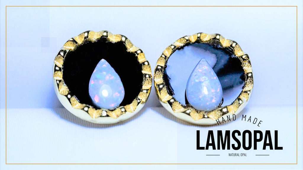 Two handmade Lamsopal natural opal teardrop stud earrings set in gold and white bezel settings, displayed side-by-side on a light blue background with a 'HAND MADE LAMSOPAL' text overlay.