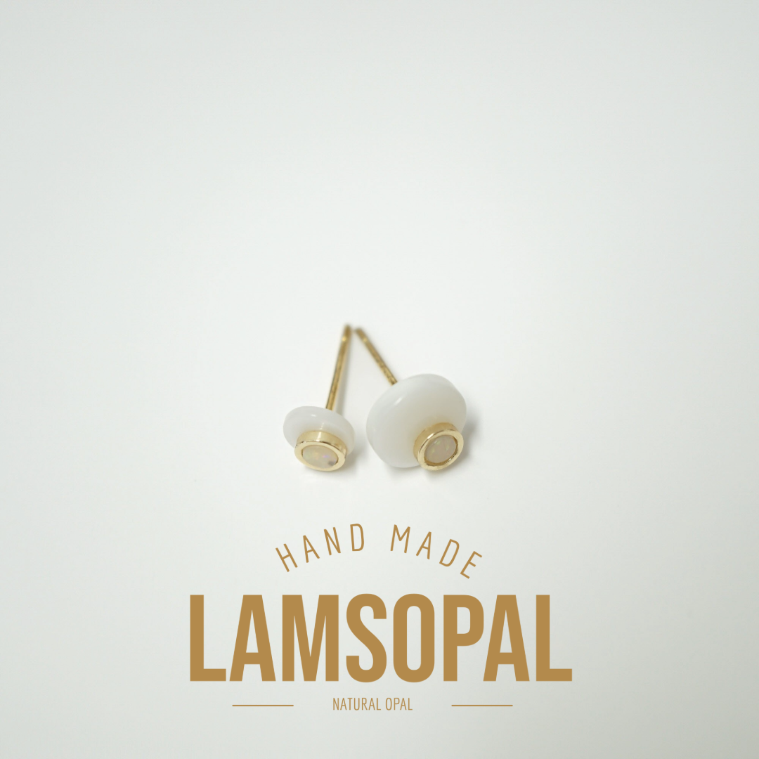 Two Lamsopal natural opal stud earrings with round milky white opal cabochons and gold posts, displayed above the text 'HAND MADE LAMSOPAL NATURAL OPAL' on a clean off-white background.