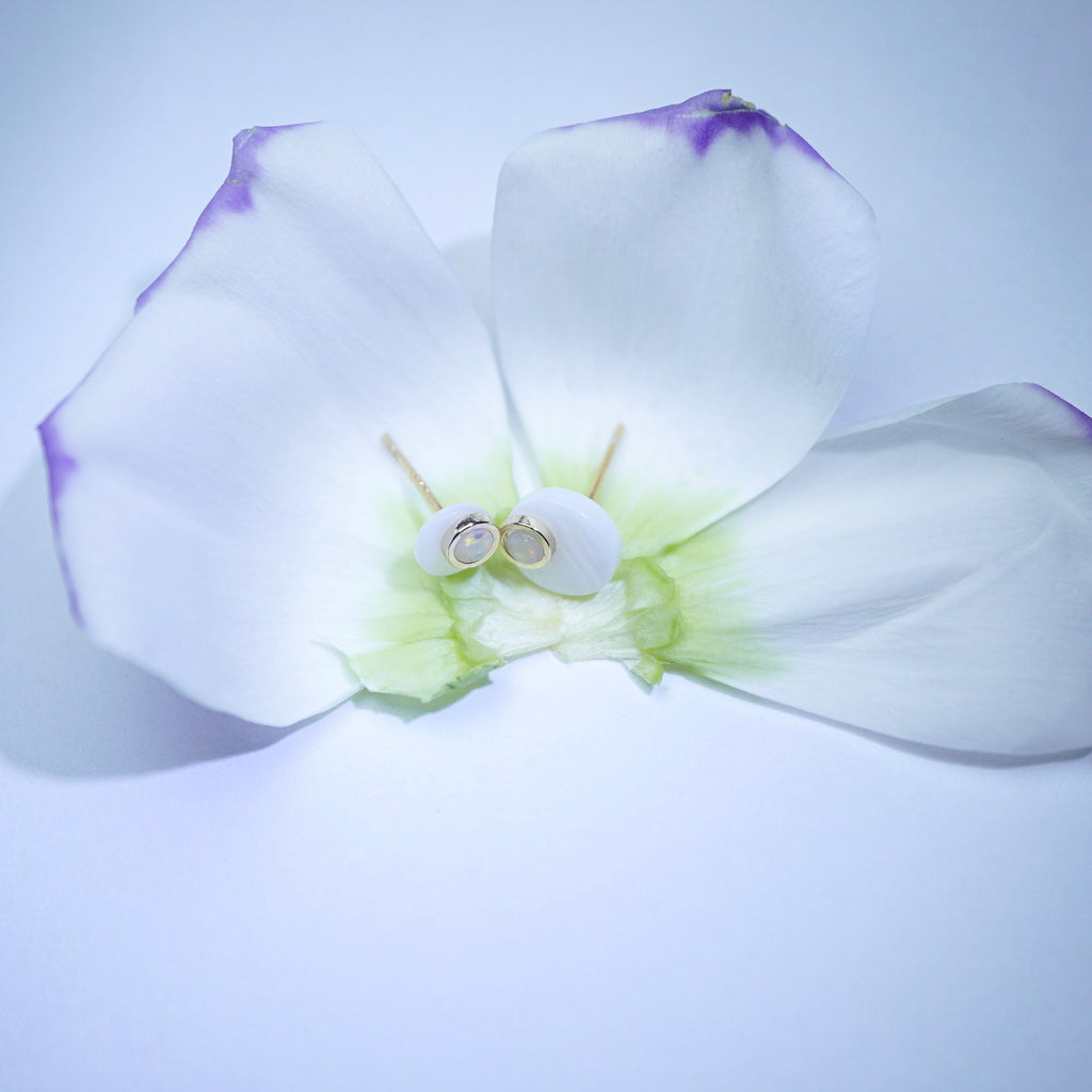 White flower with a small object on a light purple background